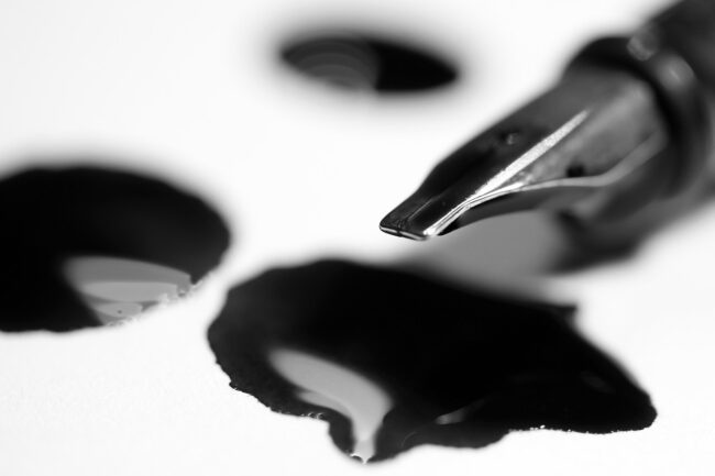 fountain pen with black ink pooled under the nib