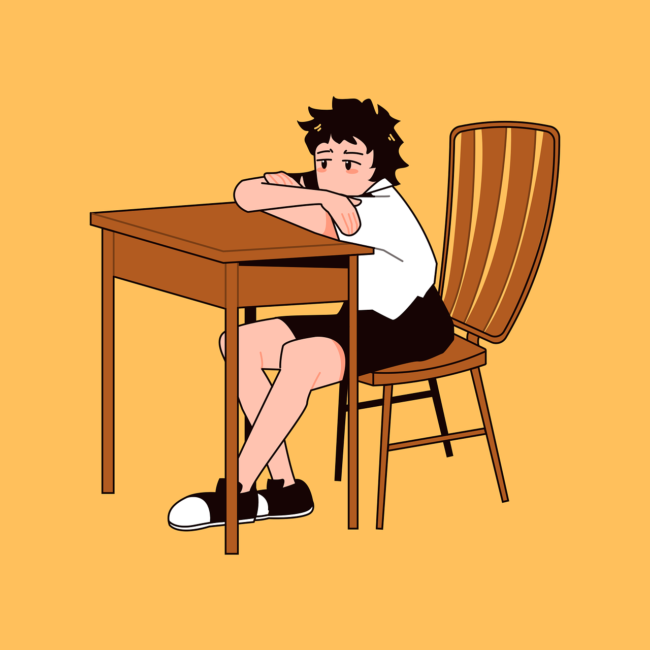 child sulking at a desk wearing shorts and a short-sleeved shirt